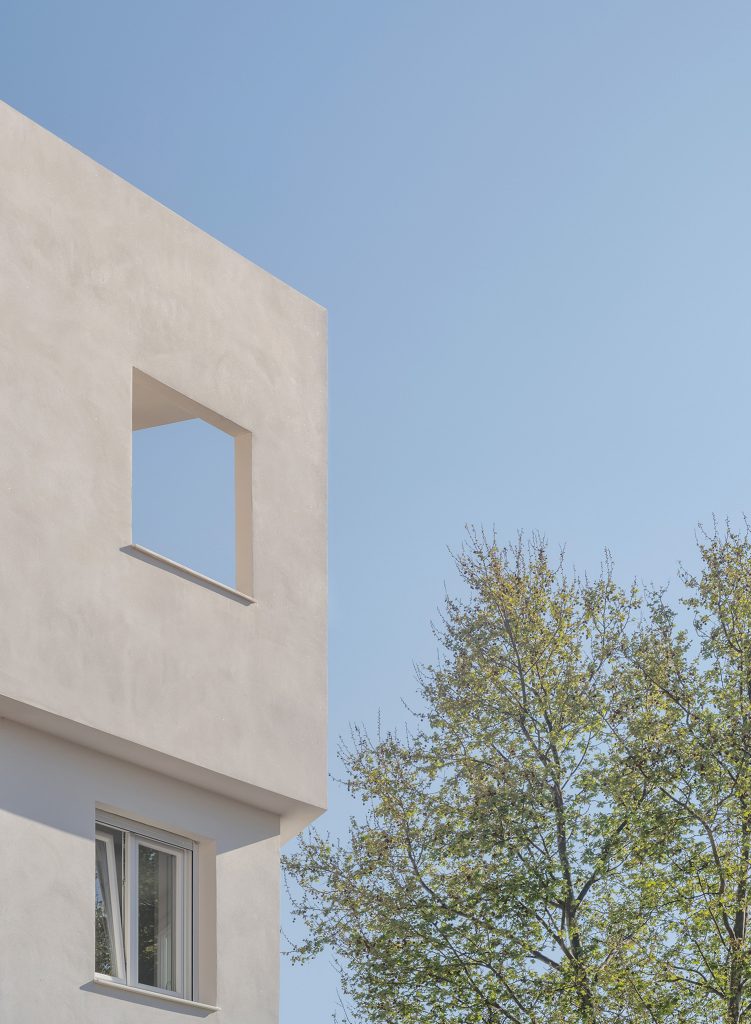 Detalle de la fachada de un edificio moderno con ventana cuadrada.