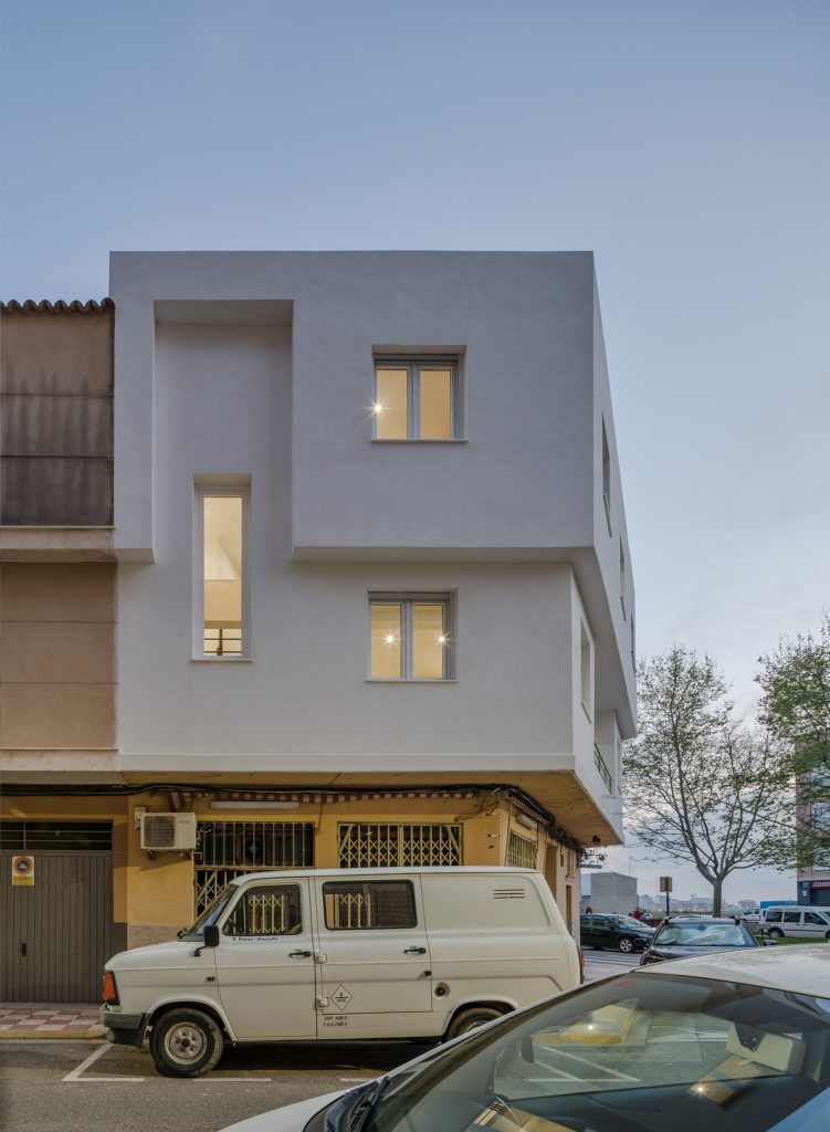 Edificio urbano moderno de esquina con fachada blanca.